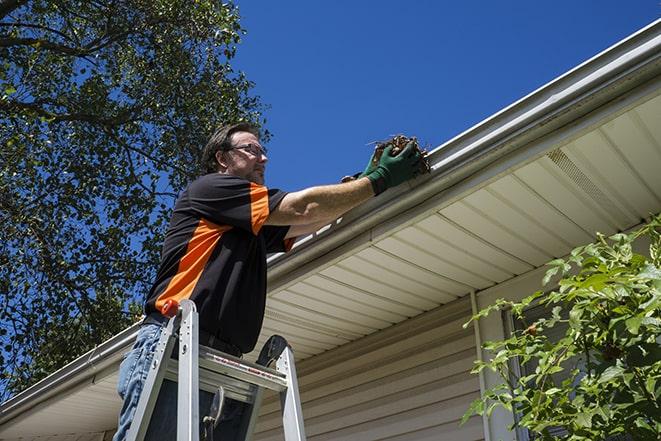 close-up of a technician fixing a gutter pipe in Affton